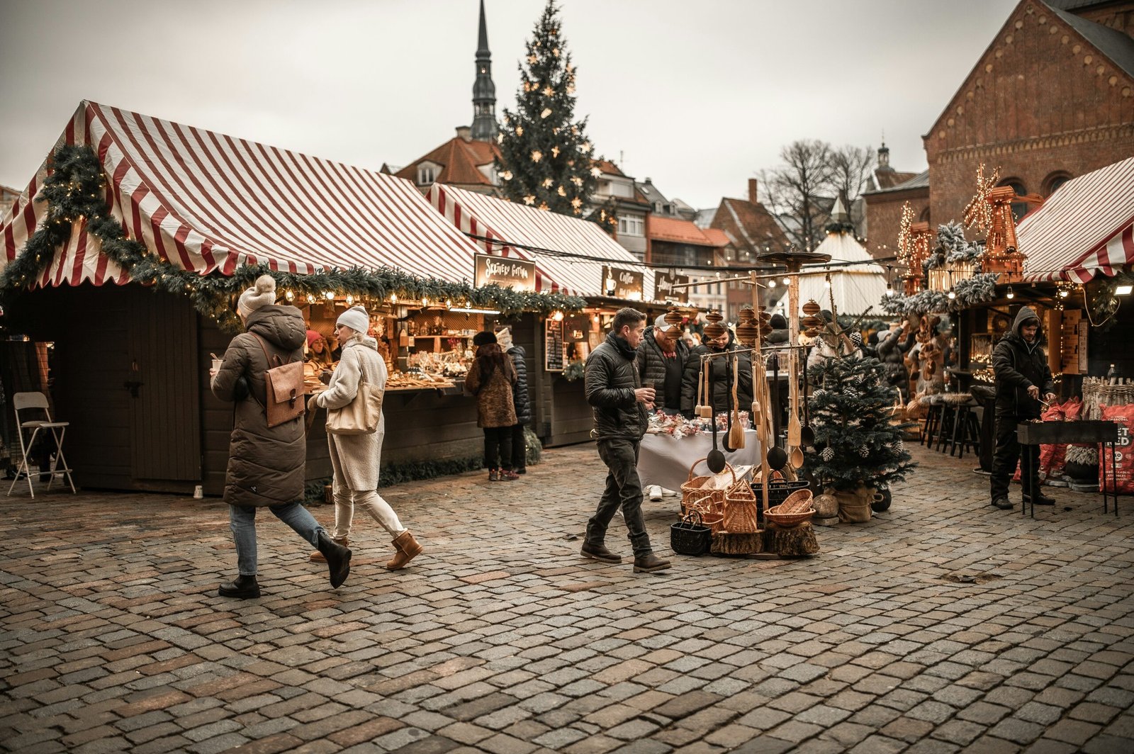 Sfeervolle kerstmarkt in Limburg met verlichte kramen, kerstboom en bezoekers